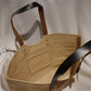 Schlep it, schlep it real good! Need something to schlep your stuff around? This is it. Cooked Concepts' Schleppit (v) Tote is made ethically in India from sustainable Jute, features leather straps and metal rivets and the design is screen printed on the front. 
