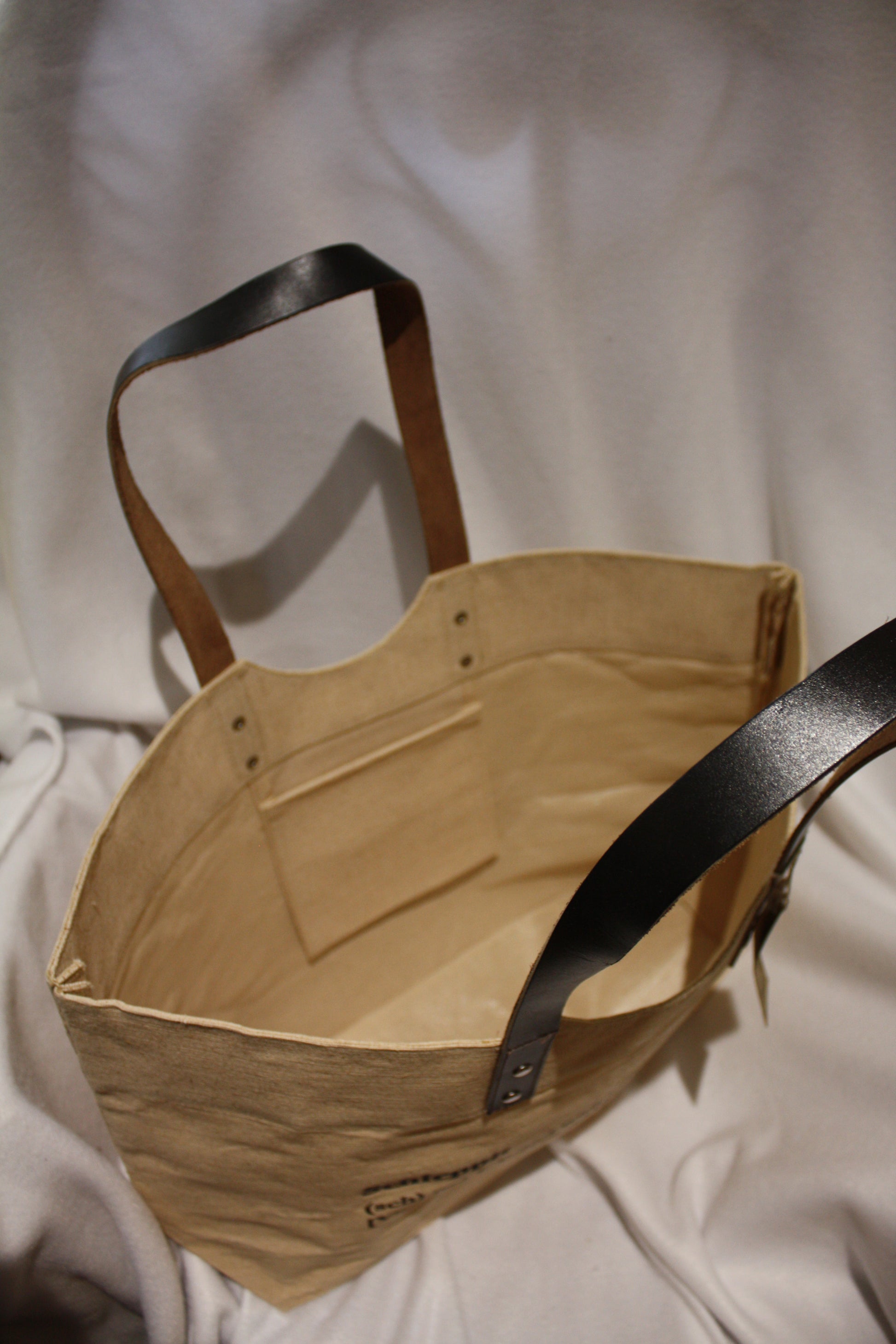 Schlep it, schlep it real good! Need something to schlep your stuff around? This is it. Cooked Concepts' Schleppit (v) Tote is made ethically in India from sustainable Jute, features leather straps and metal rivets and the design is screen printed on the front. 