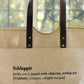 Schlep it, schlep it real good! Need something to schlep your stuff around? This is it. Cooked Concepts' Schleppit (v) Tote is made ethically in India from sustainable Jute, features leather straps and metal rivets and the design is screen printed on the front. 